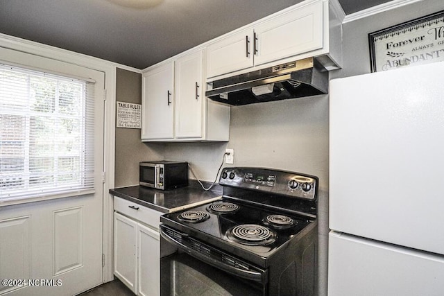 kitchen featuring black electric range, dark countertops, freestanding refrigerator, white cabinetry, and under cabinet range hood