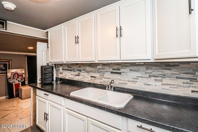 kitchen featuring sink, white cabinets, and decorative backsplash