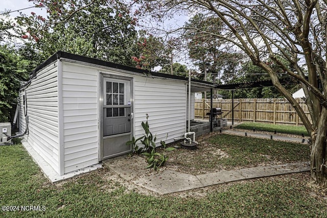 view of outdoor structure featuring fence and an outdoor structure