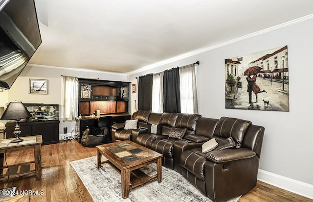 living room with baseboards, ornamental molding, and wood finished floors