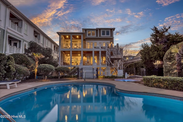 pool at dusk featuring a patio