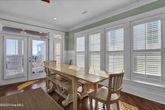 dining space with crown molding, dark hardwood / wood-style floors, and french doors