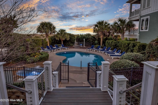 pool at dusk featuring a patio