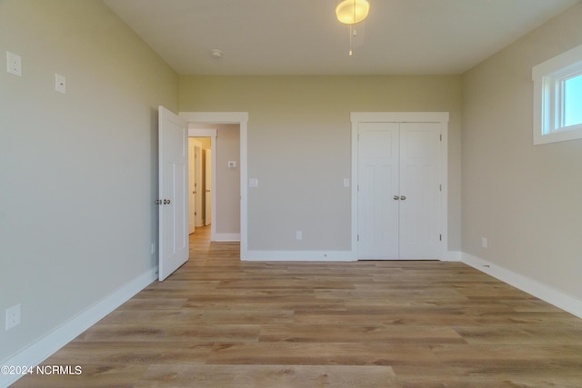 unfurnished bedroom featuring light hardwood / wood-style flooring and a closet