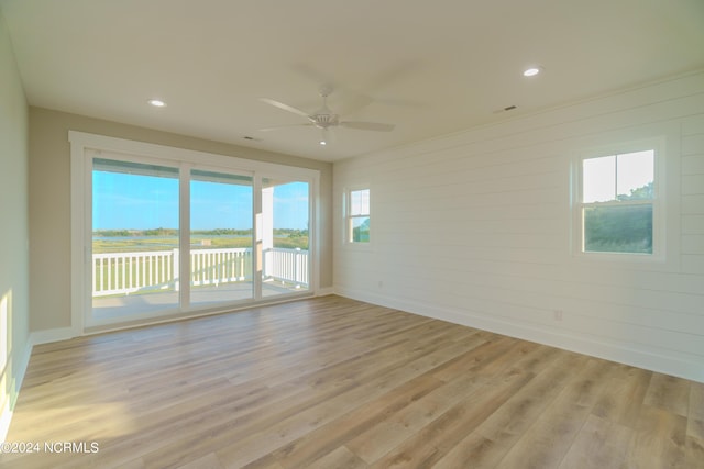 empty room featuring light wood-type flooring, a wealth of natural light, and ceiling fan