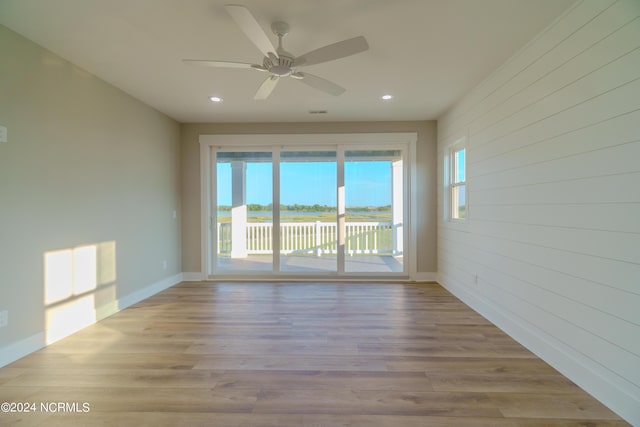 unfurnished room with plenty of natural light, ceiling fan, and light wood-type flooring