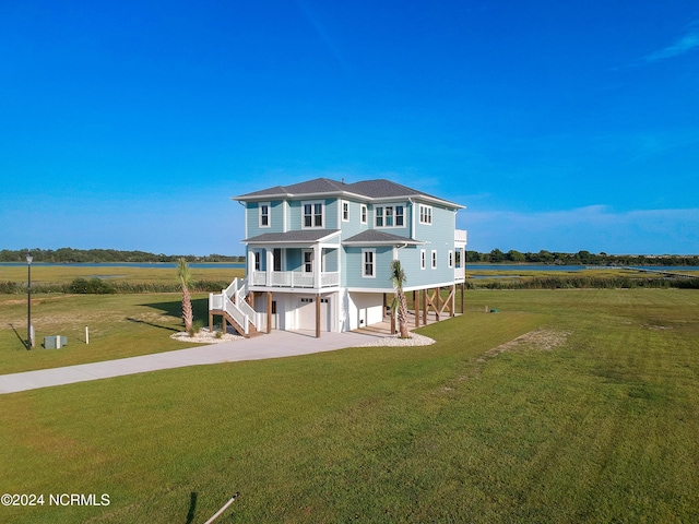 beach home featuring concrete driveway, a carport, stairway, and a front lawn