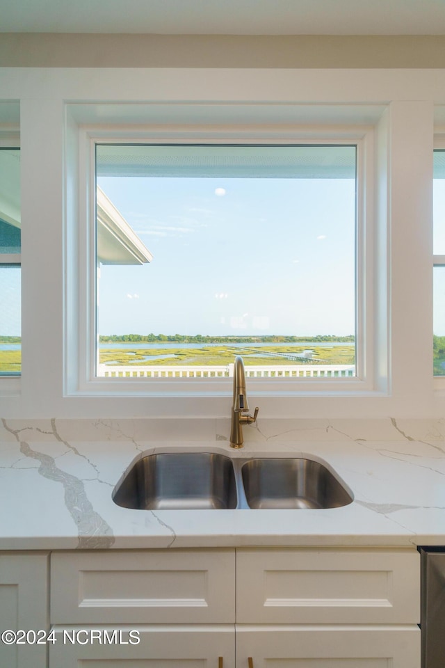 kitchen featuring light stone counters, sink, decorative backsplash, and white cabinetry