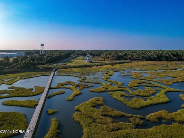 aerial view at dusk featuring a water view