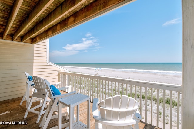 balcony with a water view and a beach view