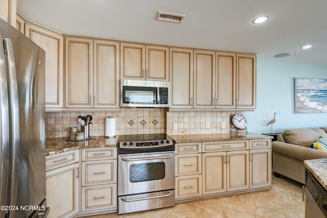 kitchen with light stone counters, stainless steel appliances, light tile patterned floors, and tasteful backsplash