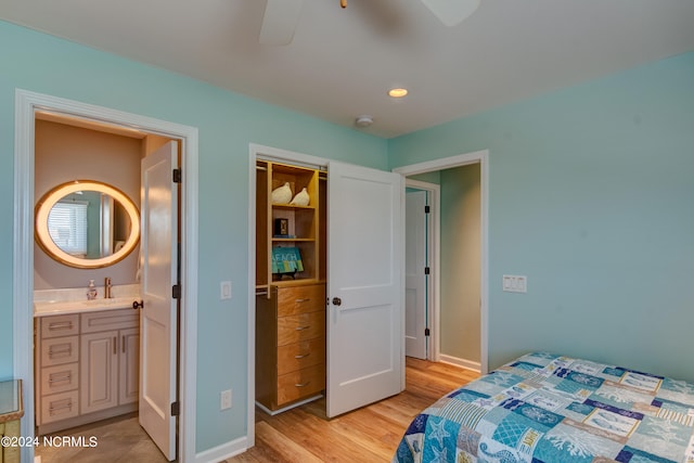 bedroom featuring ceiling fan, light hardwood / wood-style flooring, sink, and ensuite bath