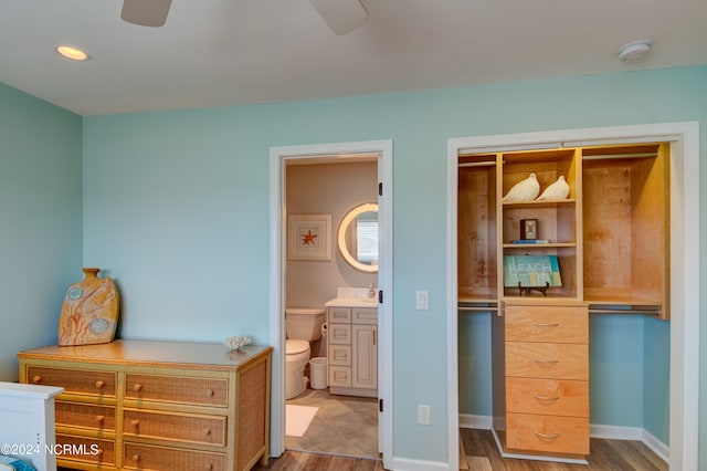 bedroom featuring connected bathroom, ceiling fan, hardwood / wood-style flooring, and sink