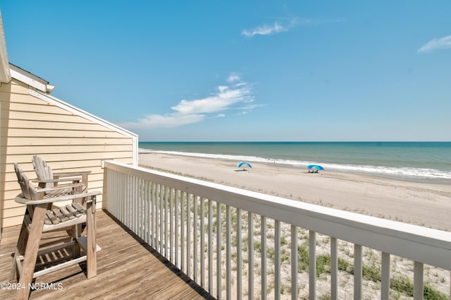 balcony with a water view and a beach view