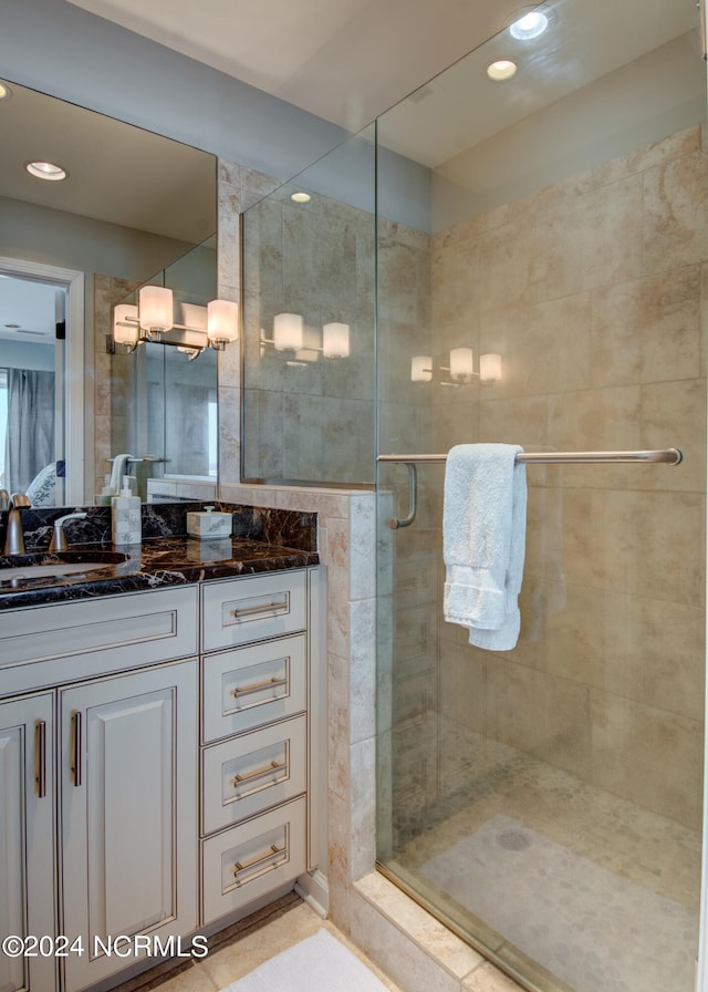 bathroom with tile patterned flooring, an enclosed shower, and vanity