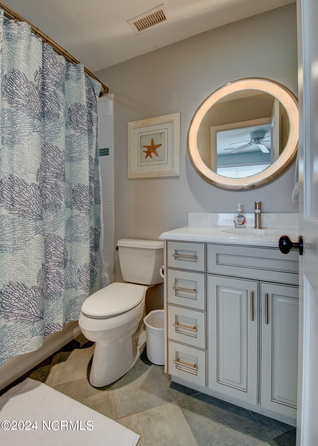 bathroom with curtained shower, vanity, toilet, and tile patterned floors