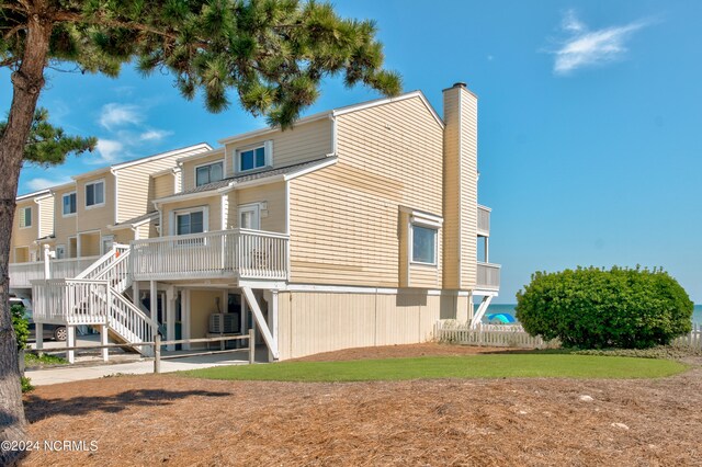 rear view of property featuring central air condition unit and a wooden deck