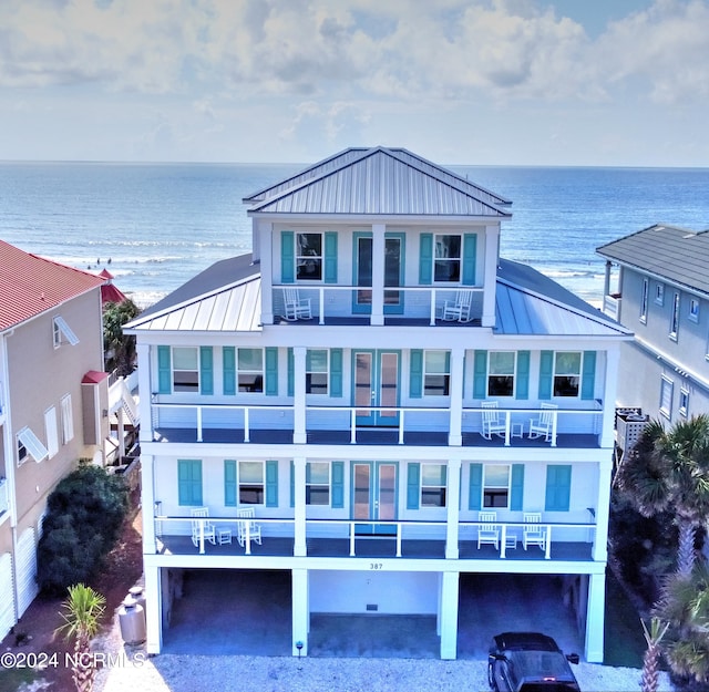 back of property featuring metal roof, a standing seam roof, and a water view