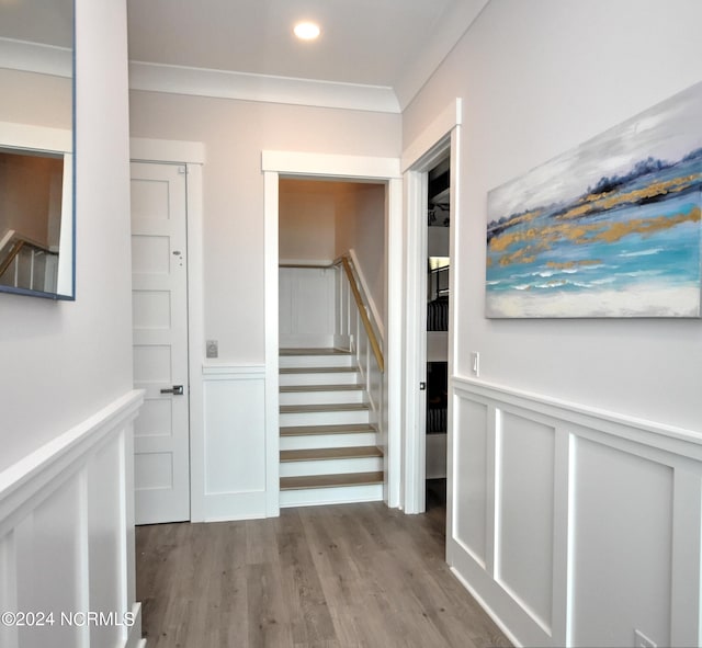 hall featuring wainscoting, ornamental molding, wood finished floors, stairs, and recessed lighting