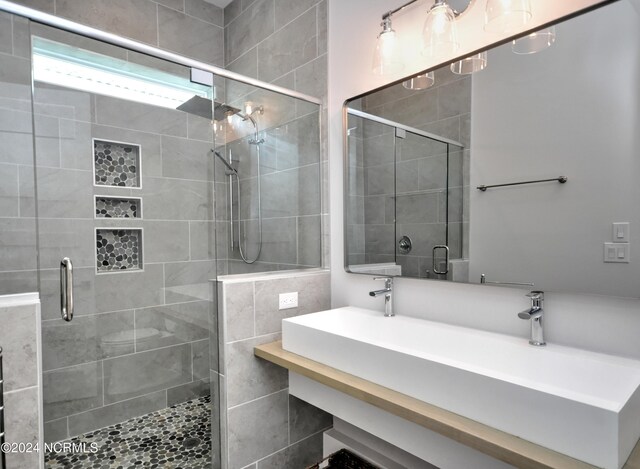 bathroom with vanity and a shower with shower door