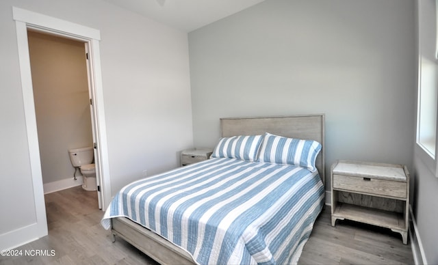 bedroom featuring light hardwood / wood-style flooring and ensuite bath