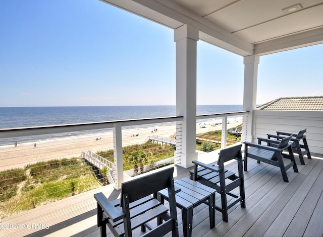 wooden deck featuring a view of the beach and a water view