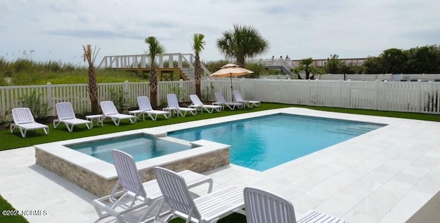 view of pool with a patio area, a fenced backyard, and a pool with connected hot tub