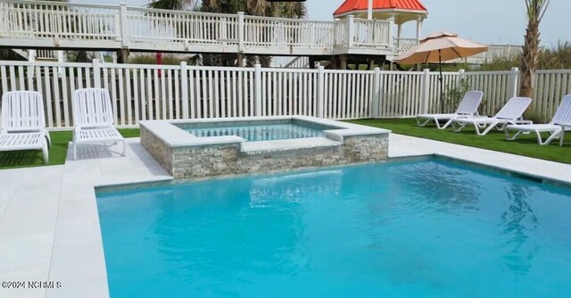 view of swimming pool with a fenced in pool, a fenced backyard, and an in ground hot tub