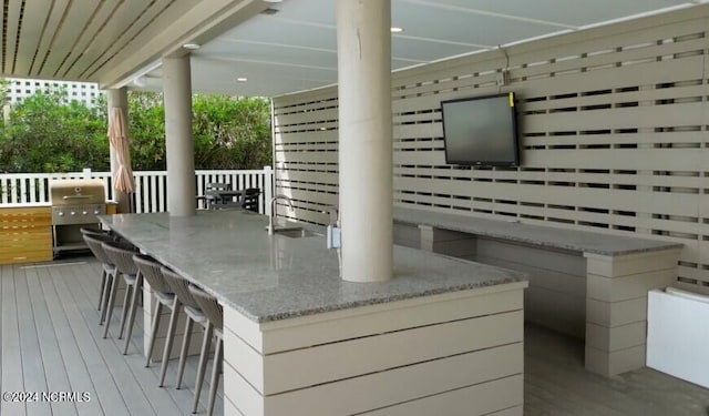 wooden deck featuring radiator heating unit, a grill, outdoor dry bar, and a sink