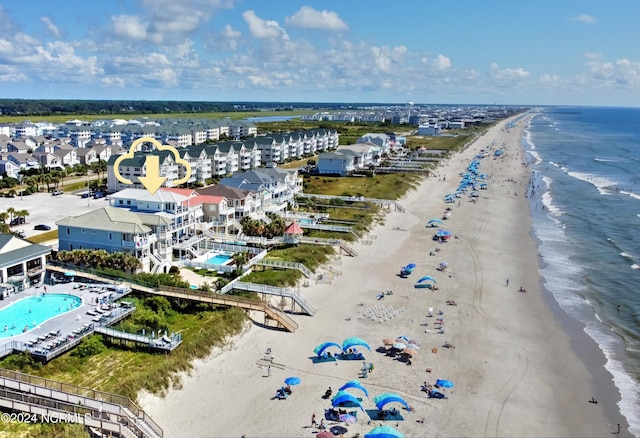 birds eye view of property featuring a water view and a beach view