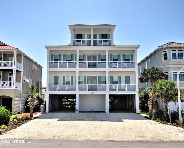 coastal inspired home featuring a balcony and a carport