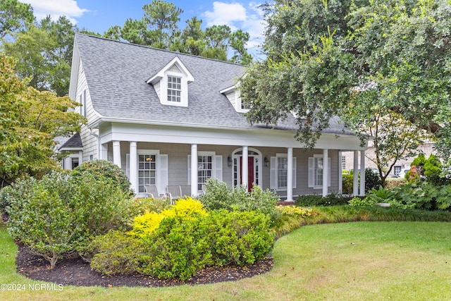 cape cod house with covered porch and a front yard