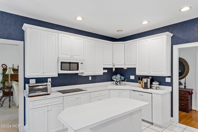 kitchen with light hardwood / wood-style flooring, sink, white appliances, and white cabinetry