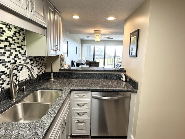 kitchen featuring a textured ceiling, ceiling fan, a sink, stainless steel dishwasher, and backsplash