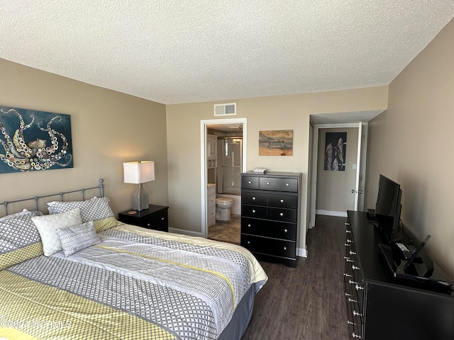 bedroom featuring ensuite bath, dark hardwood / wood-style flooring, and a textured ceiling