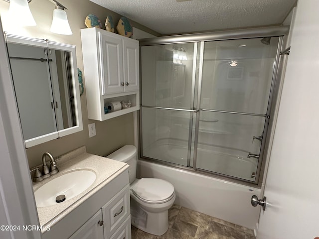 full bathroom featuring vanity, toilet, a textured ceiling, and bath / shower combo with glass door