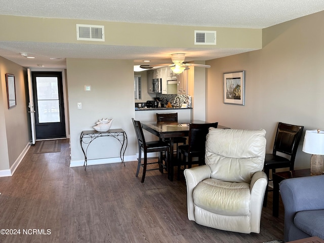 interior space with a textured ceiling, ceiling fan, and dark hardwood / wood-style flooring