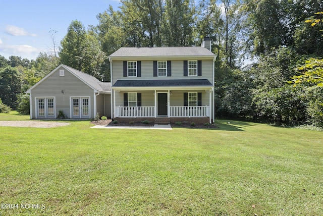 view of front of house with a front yard, a chimney, a porch, and french doors