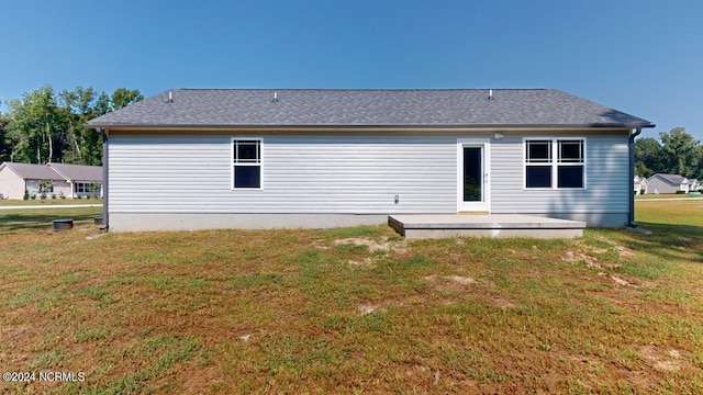 back of house featuring a lawn