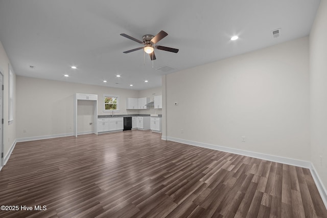 unfurnished living room featuring ceiling fan and dark wood-type flooring