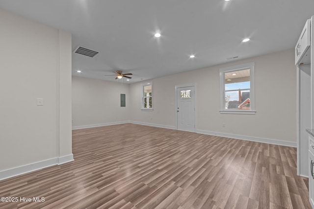 unfurnished living room featuring ceiling fan, light wood-type flooring, and electric panel