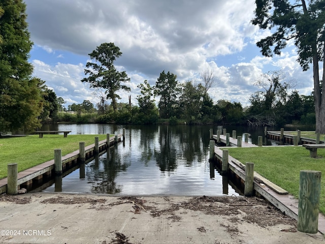 dock area with a water view and a lawn