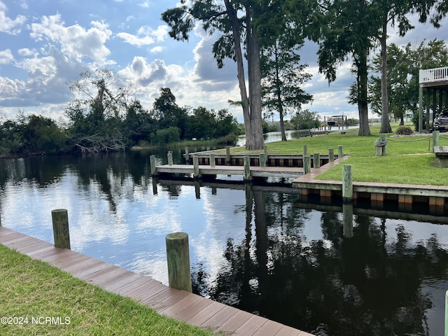 view of dock featuring a water view and a lawn