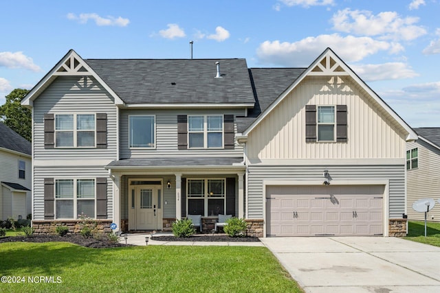 view of front facade featuring a front lawn, a garage, and covered porch