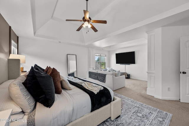 bedroom featuring ceiling fan, light carpet, and a tray ceiling