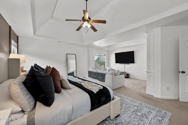 carpeted bedroom featuring a ceiling fan, a tray ceiling, and baseboards