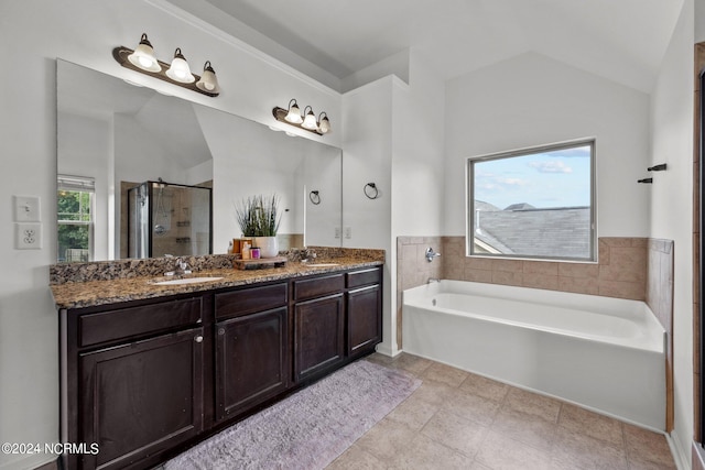 bathroom featuring vanity, vaulted ceiling, separate shower and tub, and tile patterned flooring