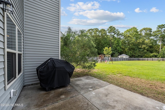 view of patio featuring a grill, fence, and a playground