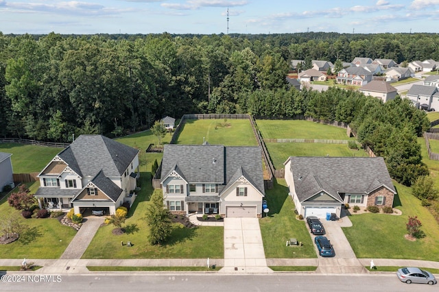 drone / aerial view featuring a residential view and a wooded view