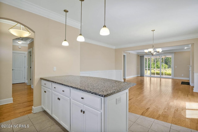 kitchen featuring light hardwood / wood-style flooring, pendant lighting, and ornamental molding